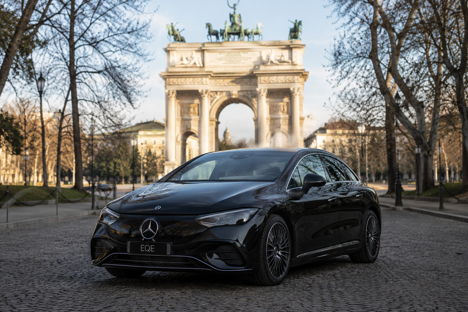 Electric Mercedes EQE chauffeur car in Milan near Arco della Pace for private luxury transfer service